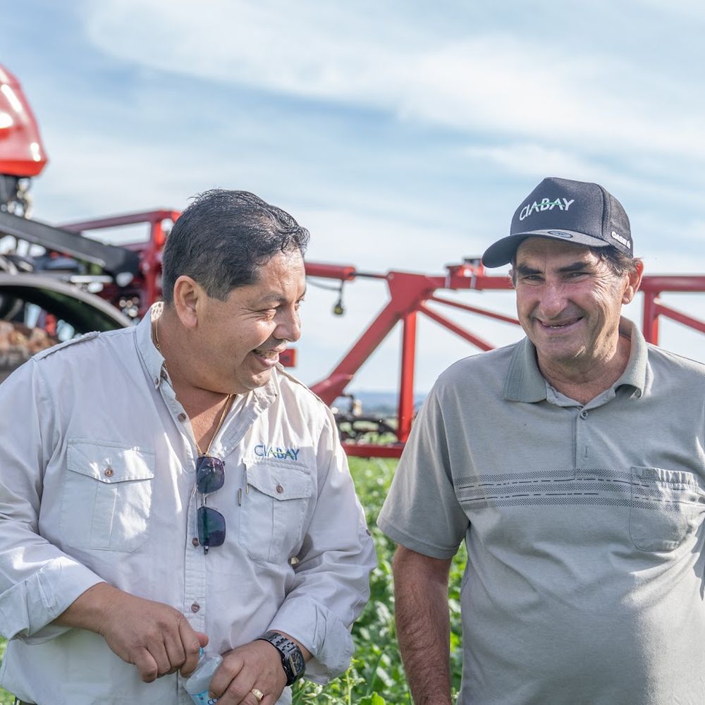 Asesor de CIABAY conversando con un productor junto a un pulverizador Case IH
